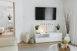 a living room with a tv on the wall at Lynwood Luxe Mudgee in Mudgee
