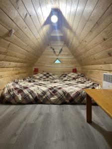 a bed in a room with a wooden ceiling at Chalet typique des Pyrénées in Boutx