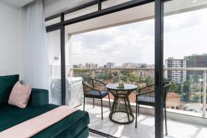 een slaapkamer met een bed, een tafel en stoelen bij Gatundu Heights in Nairobi