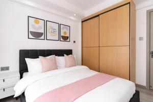een slaapkamer met een groot bed en een houten kast bij Gatundu Heights in Nairobi