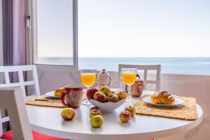 a white table with food and glasses of orange juice at Casa do Cais in Calheta +34 photos