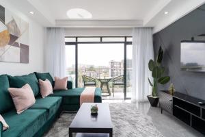 een woonkamer met een groene bank en een groot raam bij Gatundu Heights in Nairobi