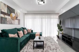 een woonkamer met een groene bank en een tafel bij Gatundu Heights in Nairobi +2 foto's