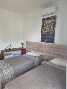 a hotel room with two beds and a picture on the wall at Garcida in Governador Celso Ramos +20 photos