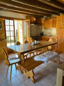 Una cocina con una gran mesa y sillas de madera. en Chalet typique des Pyrénées, en Boutx