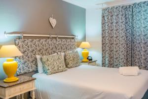 a bedroom with a large white bed with two lamps at Casa do Cais in Calheta