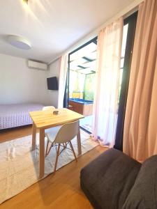 a room with a table and a bedroom with a bed at Grand Relax Suites in Diakopto