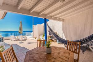 a patio with a hammock and a table and chairs at Casa do Cais in Calheta