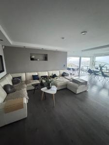 a living room with a white couch and a table at Villa med 4 soverom, sjøutsikt og hage ved lokal badestrand in Bergen