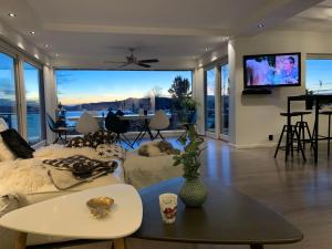 a living room with a couch and a table at Villa med 4 soverom, sjøutsikt og hage ved lokal badestrand in Bergen