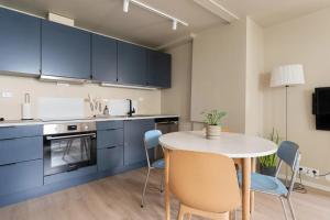 a kitchen with blue cabinets and a table and chairs at Elegant apartment in city centre in Tromsø