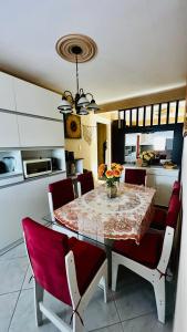 a dining room table with red chairs and a kitchen at Paraíso Tropical em Porto Seguro in Porto Seguro +118 photos