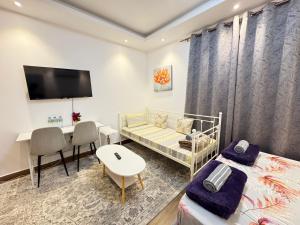 a bedroom with a bed and a desk and a table at Luxury Private Room near airport in Abu Dhabi