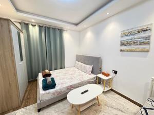 a small bedroom with a bed and a table at Luxury Private Room near airport in Abu Dhabi