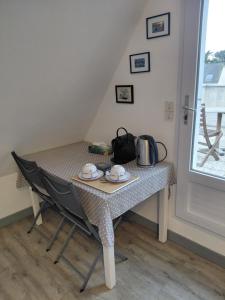 a table with two chairs and a tea kettle on it at Donemat in Arzon