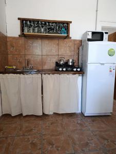 a kitchen with a white refrigerator and a sink at Lavanda y Romero in Villa Yacanto