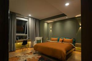 拉合尔Gold Crest Mall Luxury Apartments with Balcony by Prime Lodging in DHA Lahore的一间卧室，里面有一张床、一张桌子和一台电视。 更多20张照片