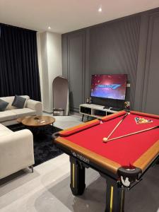 拉合尔Gold Crest Mall Luxury Apartments with Balcony by Prime Lodging in DHA Lahore的客厅设有台球桌和电视。