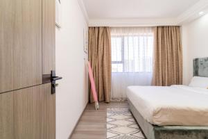 een hotelkamer met een bed en een raam bij Gatundu Heights in Nairobi
