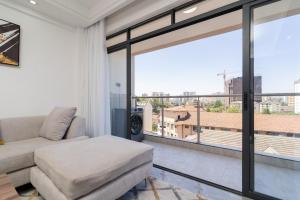een woonkamer met een bank en een groot raam bij Gatundu Heights in Nairobi