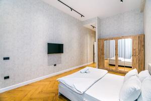 バクーにあるAmazing VIP Apartment MARIOTTのベッドと壁にテレビが掛かった寝室