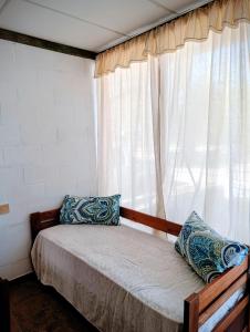 a bed sitting in a room with a window at Lavanda y Romero in Villa Yacanto