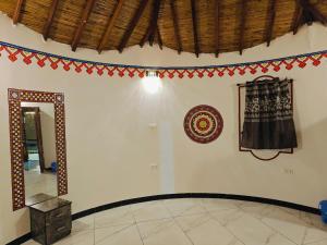 a room with a mirror and decorations on the wall at Dholavira Desert Homestay in Dholovira +2 photos