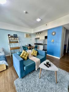 a living room with a blue couch and a table at Bleu Suite in Abreeza Place Davao City in Sampong +3 photos