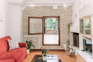 a living room with a red couch and a fireplace at Palladio Apartment - Vista Fiume, In Centro con Garage in Vicenza