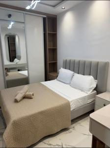 a bedroom with a large bed with a mirror at Apartement luminéo hammamet nord in Hammamet
