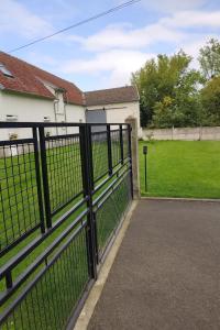 a black fence in front of a yard at La longère des cerisiers 