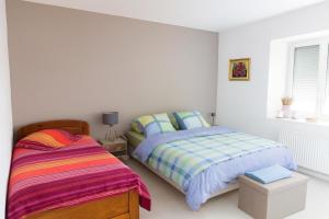 a bedroom with two beds and a window at La longère des cerisiers 