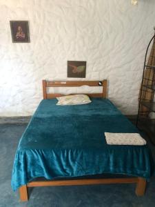 a bedroom with a bed with a blue blanket at Huanchaco Surf Camp in Huanchaco +41 photos