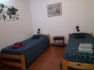 a room with two beds and a table and a desk at DEPARTAMENTO EN LOMA HERMOSA 2 in Loma Hermosa