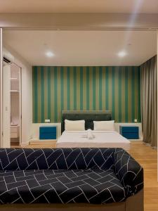 a bedroom with a large bed and green walls at Platinum KLCC by Like Home KUALA LUMPUR in Kuala Lumpur