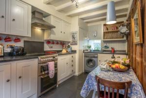 a kitchen with a table with a bowl of fruit on it at Llys-Derwin in Dolbenmaen +22 photos