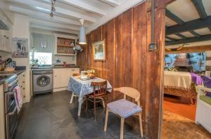 a kitchen with a table and chairs and a bedroom at Llys-Derwin in Dolbenmaen