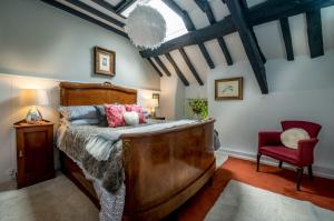 a bedroom with a large bed and a red chair at Llys-Derwin in Dolbenmaen