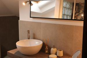 a bathroom with a white bowl sink and a mirror at Suite Cascina Balocco in Neive +5 photos