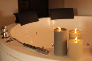 two candles sitting on top of a bath tub at Suite Cascina Balocco in Neive +4 photos