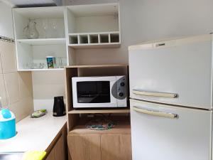 a kitchen with a white refrigerator and a microwave at Departamento Oberá-1 in Oberá +6 photos