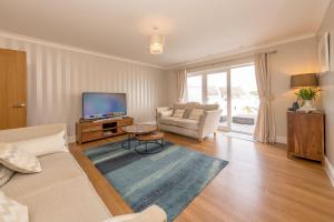 Una sala de estar con un sofá y un televisor. en Angorfa, en Y Felinheli