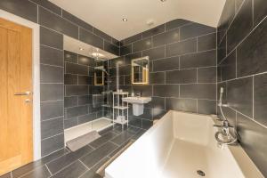 Un baño con una bañera grande y un lavabo. en Angorfa, en Y Felinheli 22 fotos más