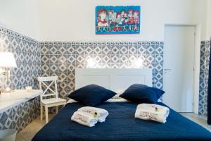 a bedroom with a blue bed with pillows on it at L'Opera Buffa in Palermo