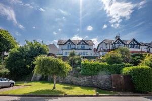 Una casa grande con un muro de piedra y un coche. en Angorfa, en Y Felinheli
