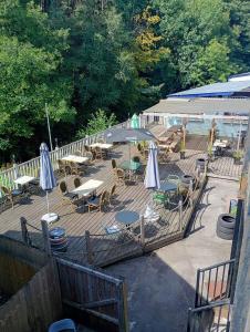 Un patio al aire libre con mesas, sillas y sombrillas. en Phat Smokehouse, en Abertillery