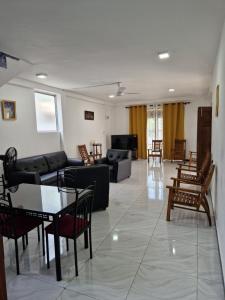 a living room with couches and a table and chairs at HANSI Villa in Piliyandala +4 photos