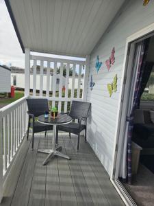 a patio with a table and chairs on a porch at Haven Golden Sands Holly Drive 24 in Mablethorpe