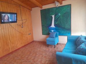 a living room with a blue couch and a tv at cabaña milita in Chile Chico
