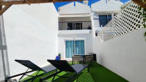 a balcony with chairs and a white building at Marbella Golf 101 - Bungalow con 2 dormitorios en Maspalomas in Maspalomas